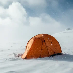 An avalanche backpack tent standing strong against snowy and windy conditions in a four-season environment.