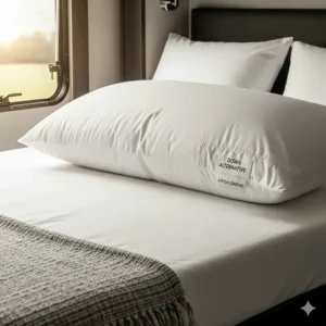 A luxurious down alternative pillow fluffed up on a bed inside an RV, emphasizing its soft and hypoallergenic qualities.