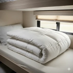 A fluffy, warm down alternative duvet folded neatly on an RV bunk bed.