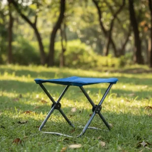 A a durable portable camp stool fully unfolded and ready for use on a grassy patch, showing its stable design.