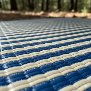 Close-up of a breathable polypropylene RV outdoor mat, highlighting its reversible and UV-resistant woven material.