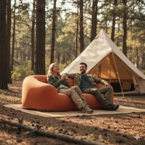 Two people relaxing comfortably on a spacious, two-seater camping sofa at a campsite.