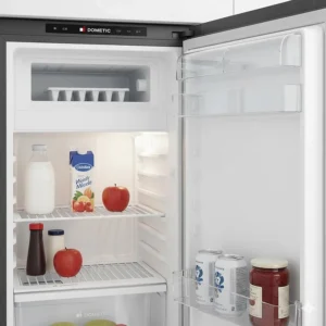Photo of the interior of the RV absorption refrigerator showing adjustable shelving, door bins, and the small freezer compartment.