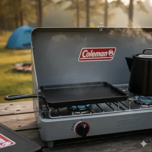Close-up of the cast-iron griddle accessory heating up on the Coleman camping stove burners.