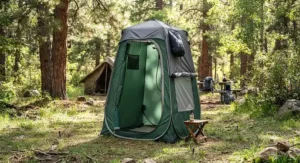 A waterproof camp shower tent with a removable rainfly for ventilation and weather protection.