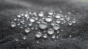 Water droplets beading on the outer shell of a 3-season sleeping bag for backpacking.