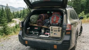 A packed summer sleeping bag for festivals loaded into the trunk alongside car camping gear