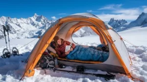 An ultralight mummy sleeping bag keeping a mountaineer warm inside a winter tent on a snowy peak